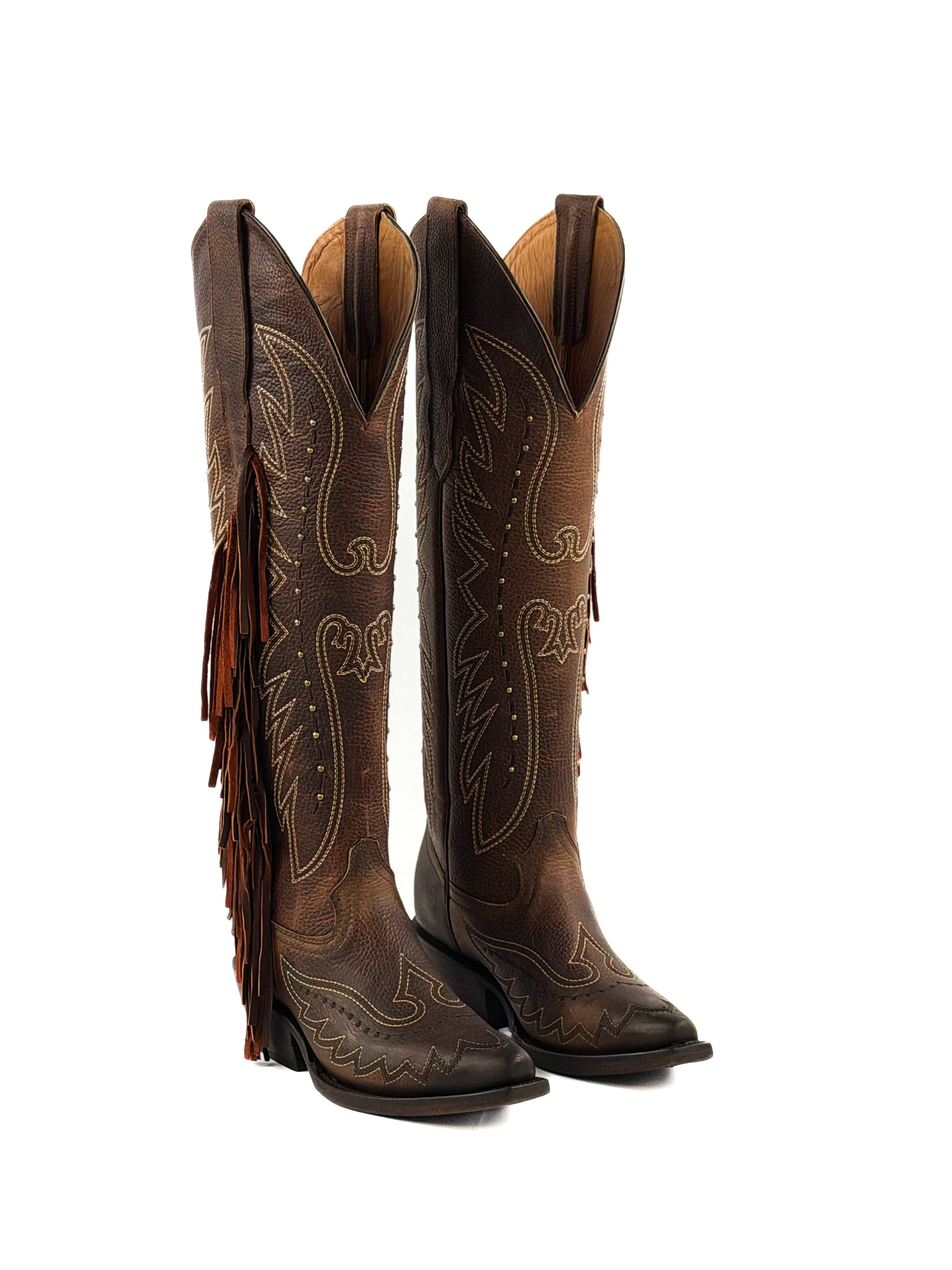 Pair of brown snip toe cowgirl boots with intricate designs, studs, fringes, and 2 inch heel.