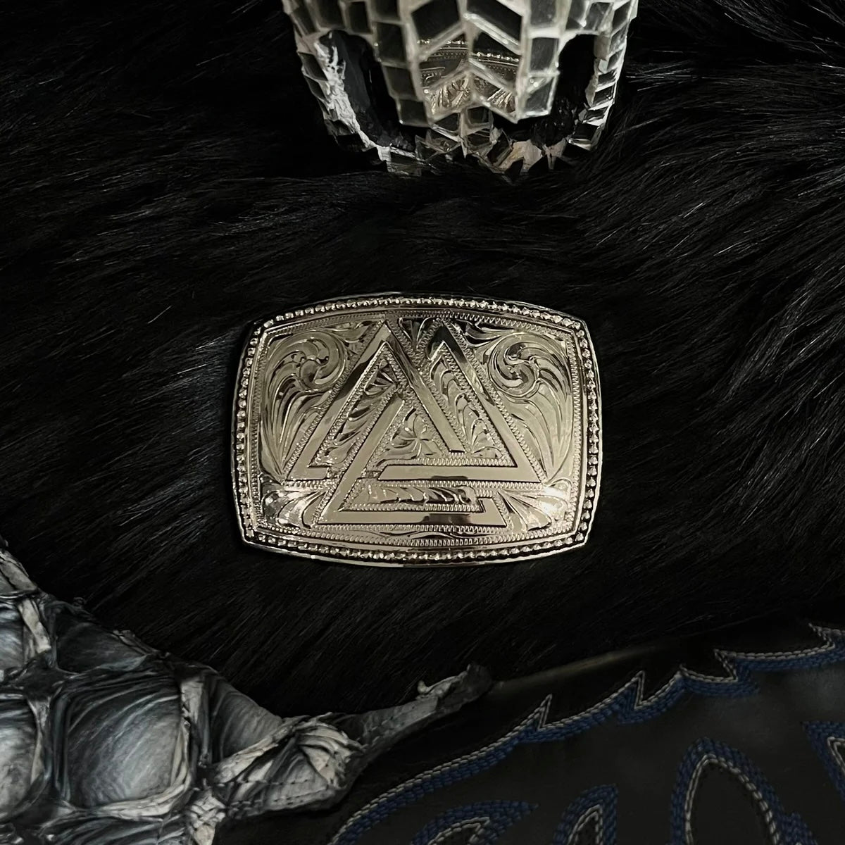 Decorative silver belt buckle with triangle logo