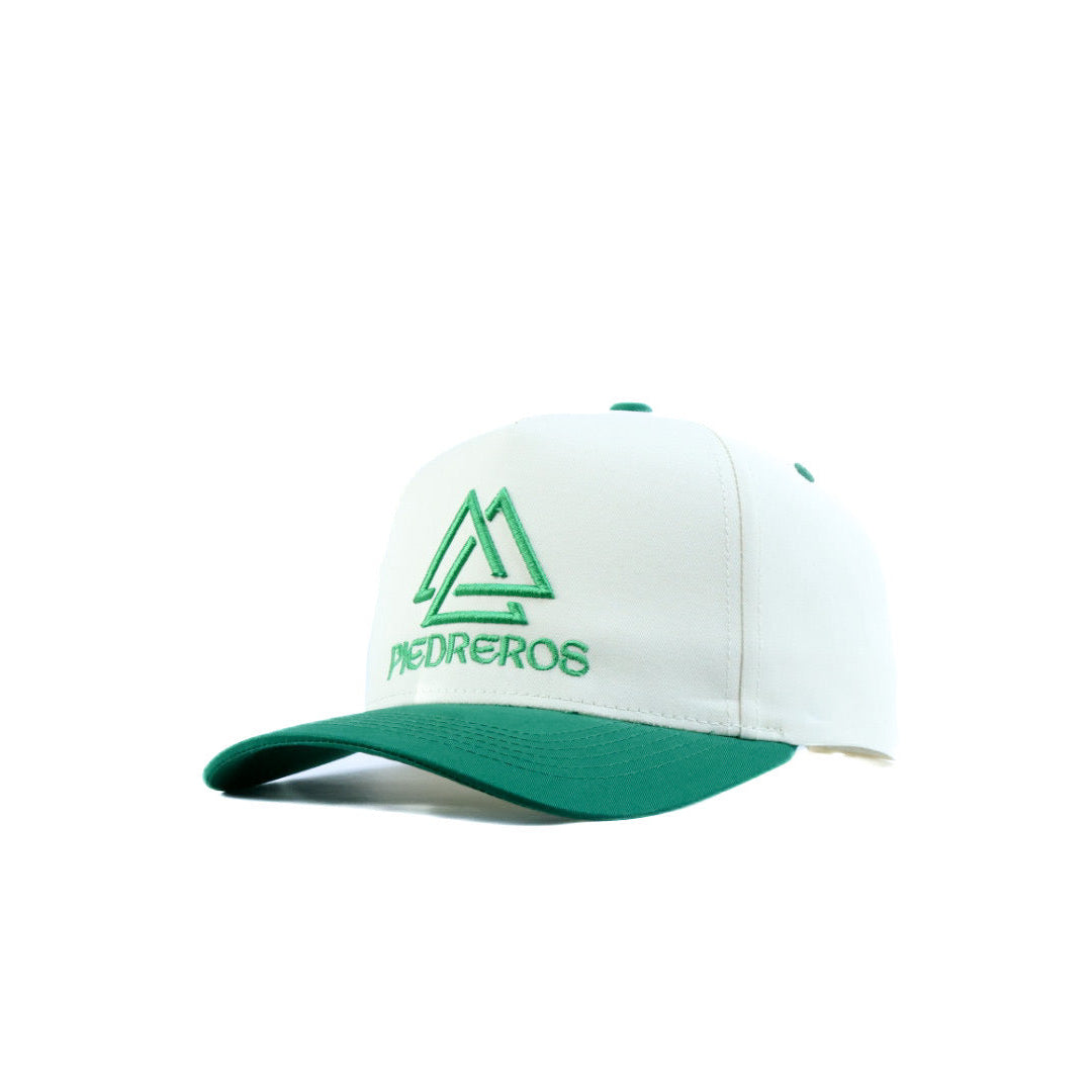 White cap with green brim and piedreros logo on a white background