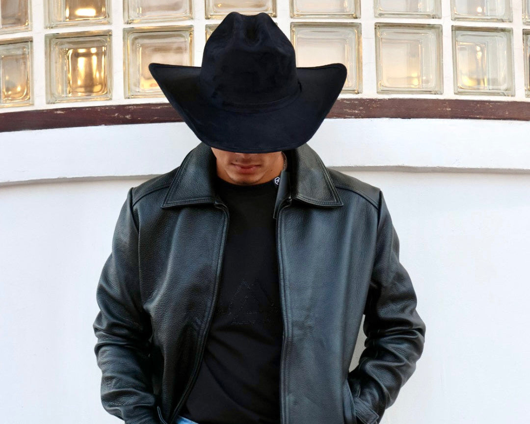 Person wearing a black leather jacket, black hat, black shirt