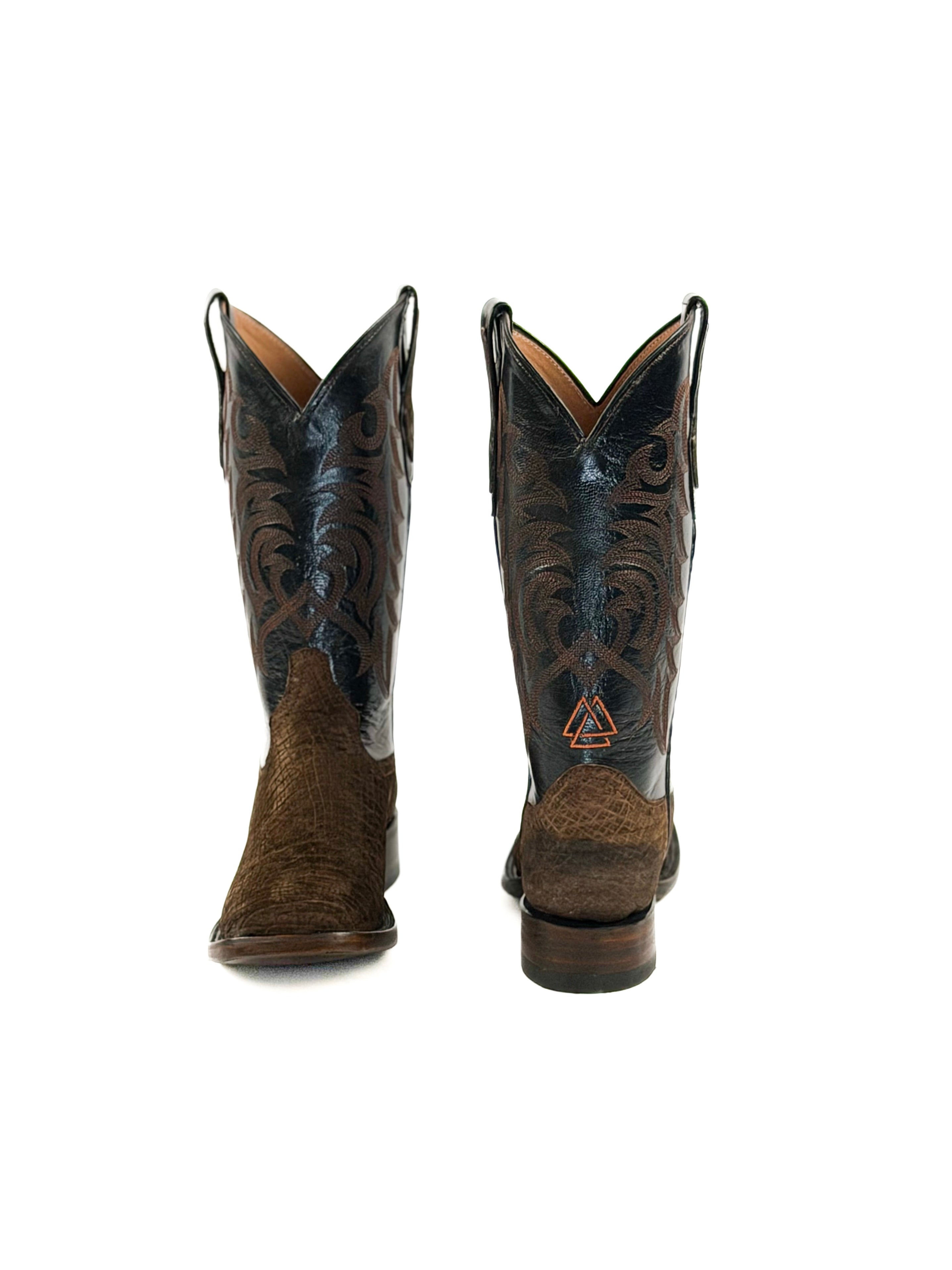 Pair of dark brown cowboy boots with intricate designs on the upper black shafts