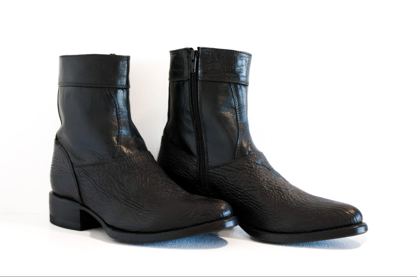Pair of black leather boots on a white background